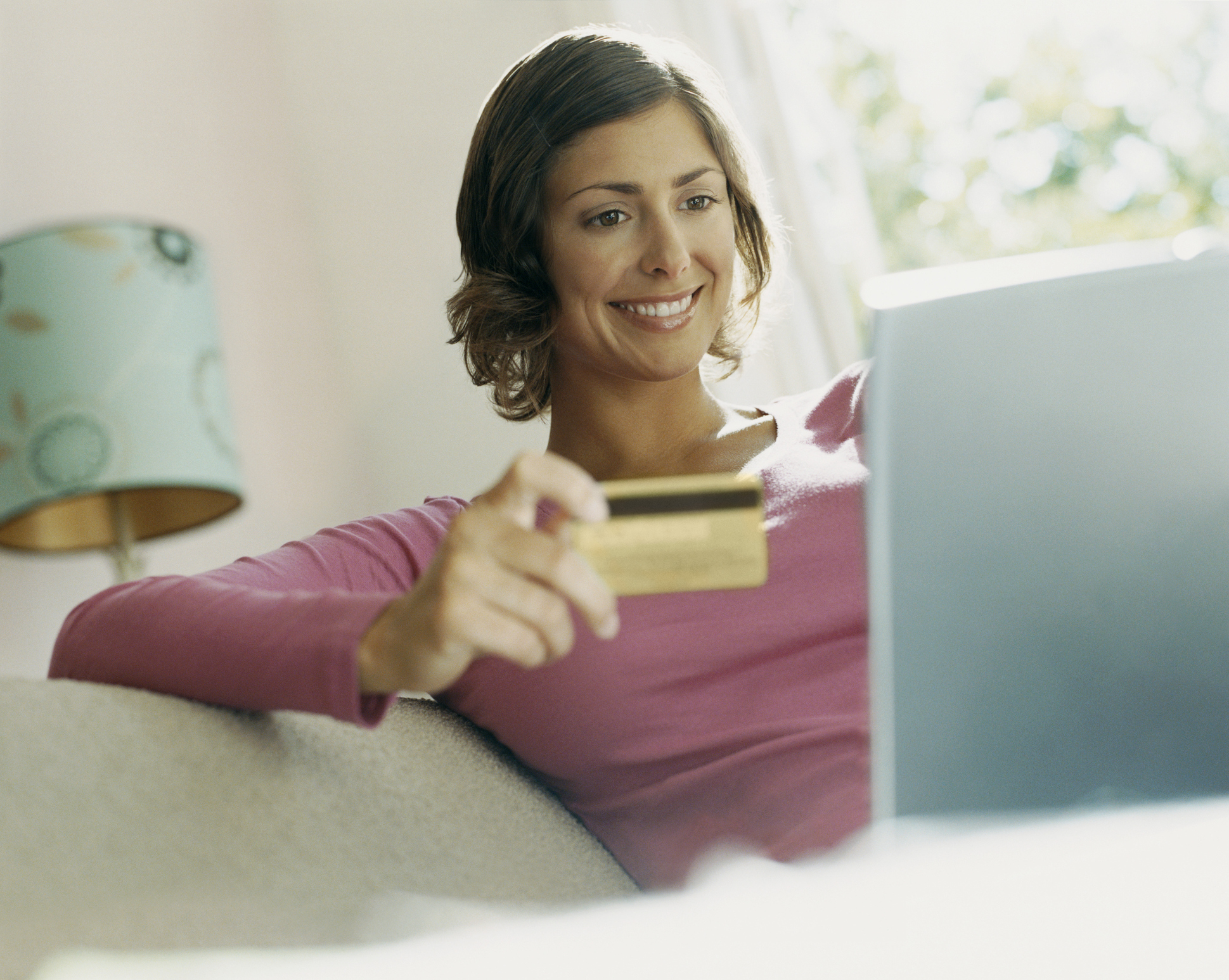 Woman Using Her Bank Card Online With A Laptop